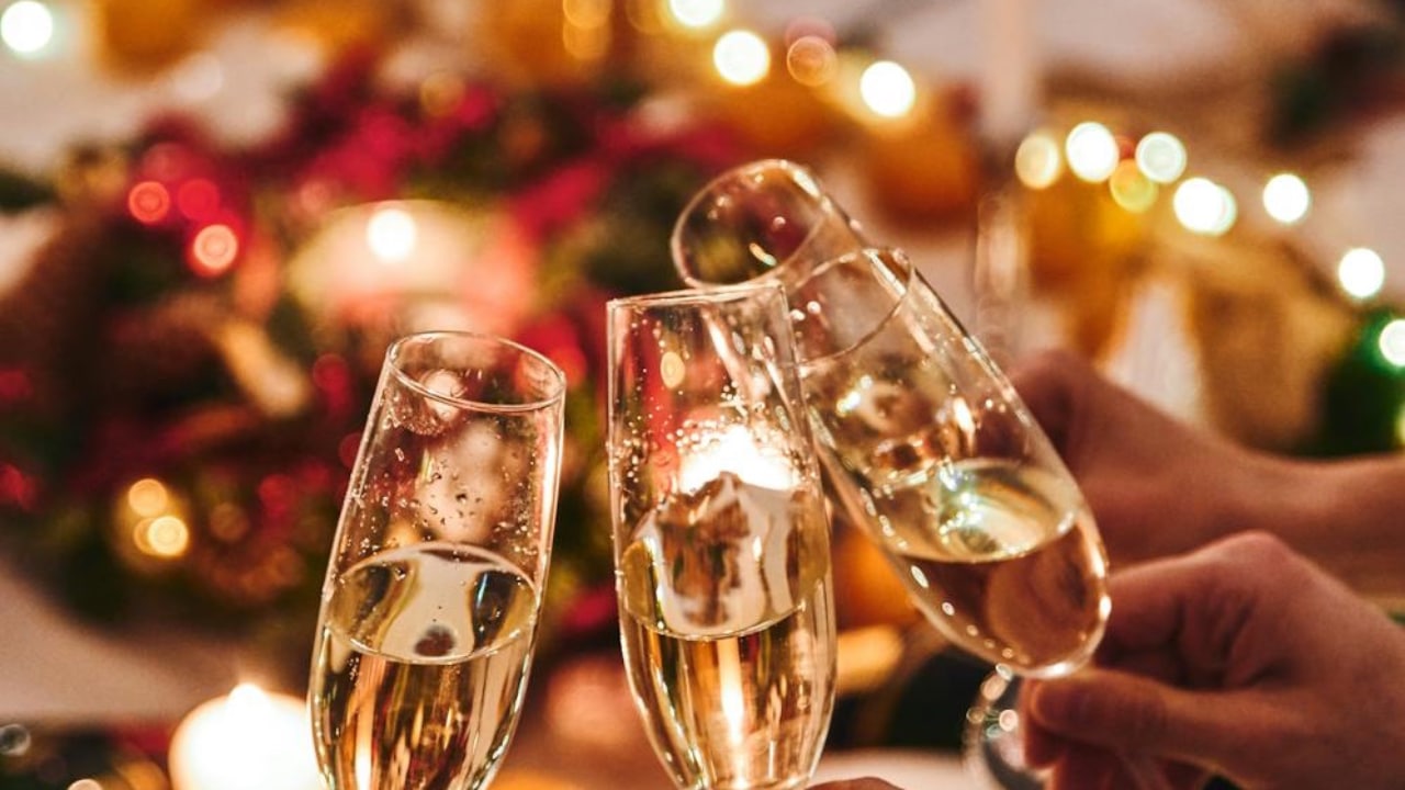 Wine glass is toasting with a festive bright background.