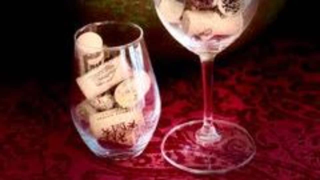 Two wine glasses, one with a stem and one without. Both are full of corks.